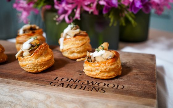 Four round pastries displayed on a wooden board.